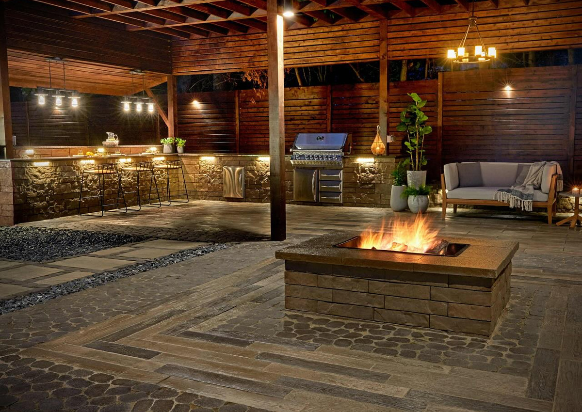 covered outdoor patio with modern square fire pit, seating area, and bar lighting after expert fire pit installation in Fort Worth, TX