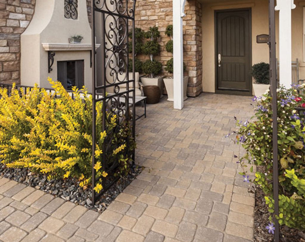 Holistic Patio Hardscaping Services in Fort Worth, TX - Holistic Patio Expert Paver Walkway Installation in Fort Worth TX g6 front entry walkway with tan stone pavers, iron gate, and garden plants created through paver walkway installation in Fort Worth, TX