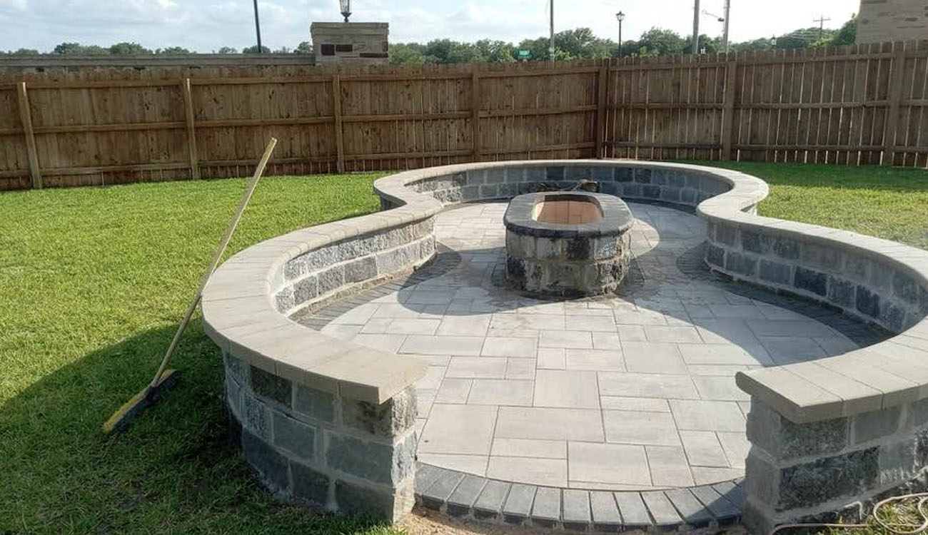 curved stone patio with built-in seating and center fire feature, highlighting Fireplace Backyard Ideas for modern outdoor spaces