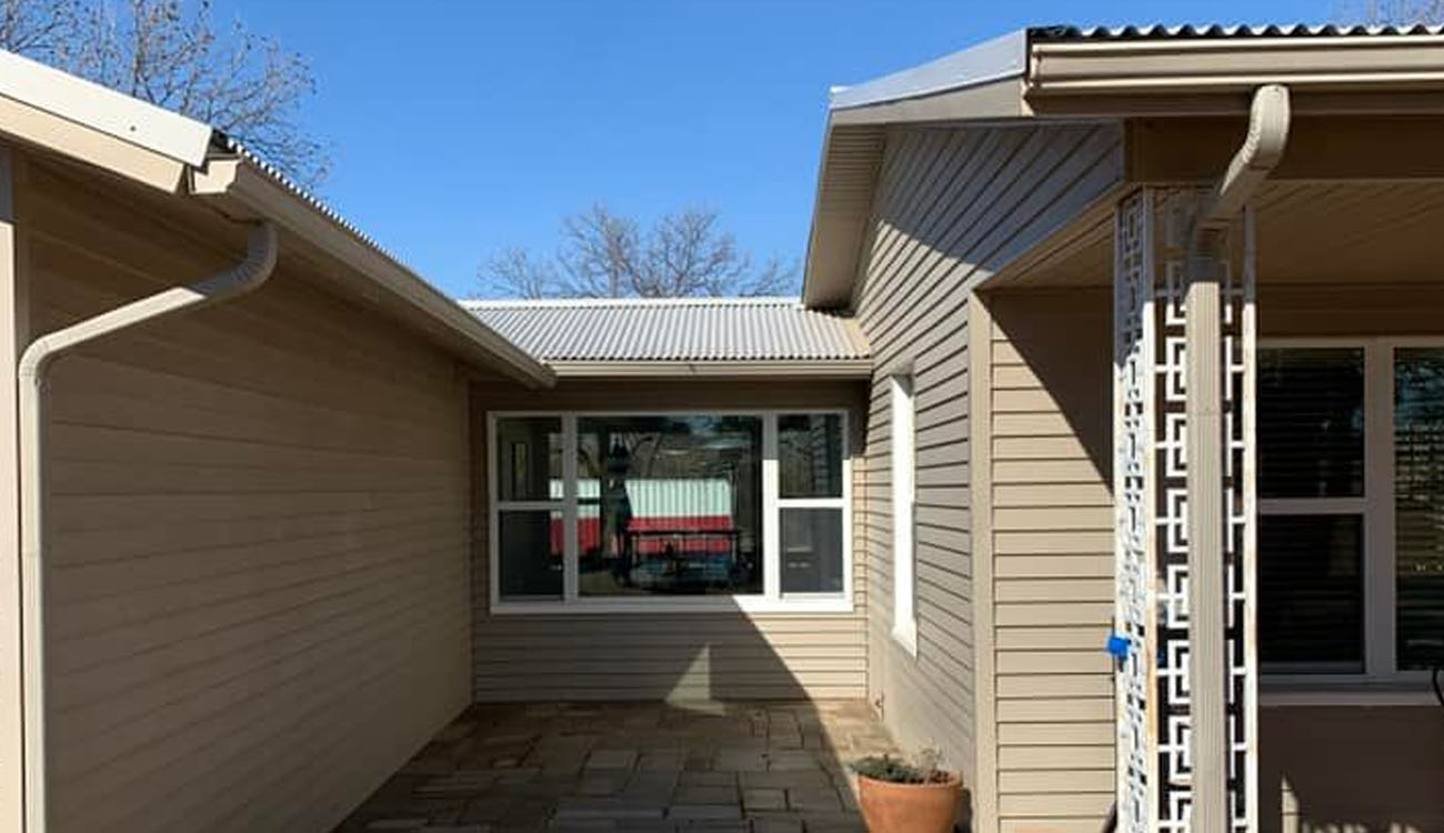 Holistic Patio Hardscaping Services in Fort Worth, TX - Holistic Patio Small Modern Patio Ideas for a Stylish Retreat c1 compact stone patio between beige siding walls, an example of Modern Patio Ideas for small backyard designs