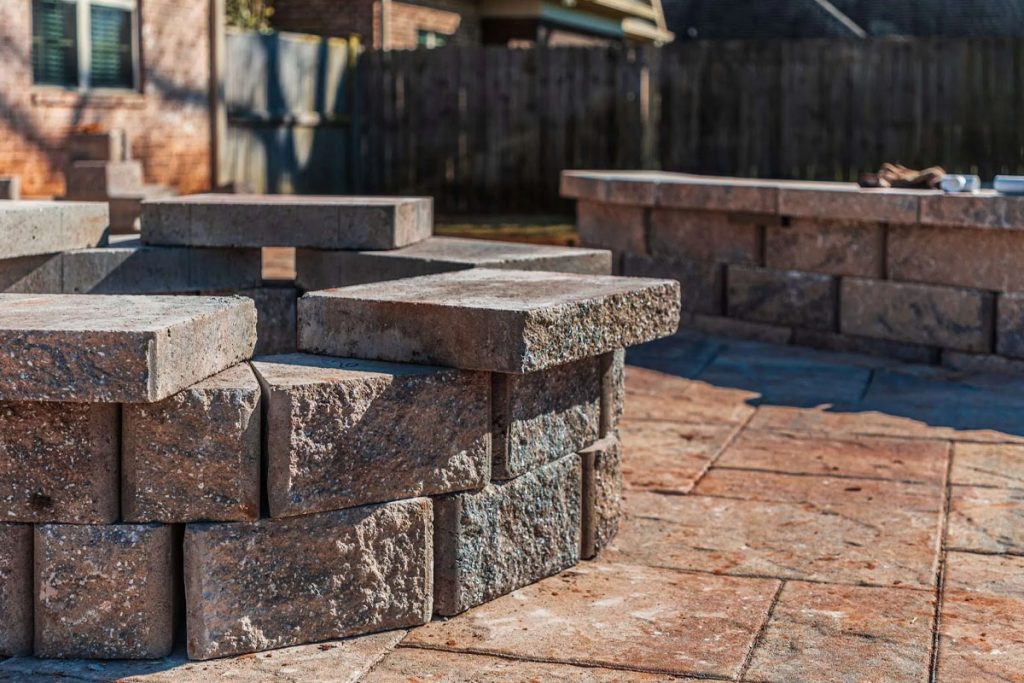 Holistic Patio Hardscaping Services in Fort Worth, TX - Outdoor Fire Pit Ideas That Warm Up Your Backyard in Denton County Header Close-up of stone pavers arranged for a backyard fire pit, showing rustic outdoor fire pit ideas for cozy and stylish outdoor spaces.