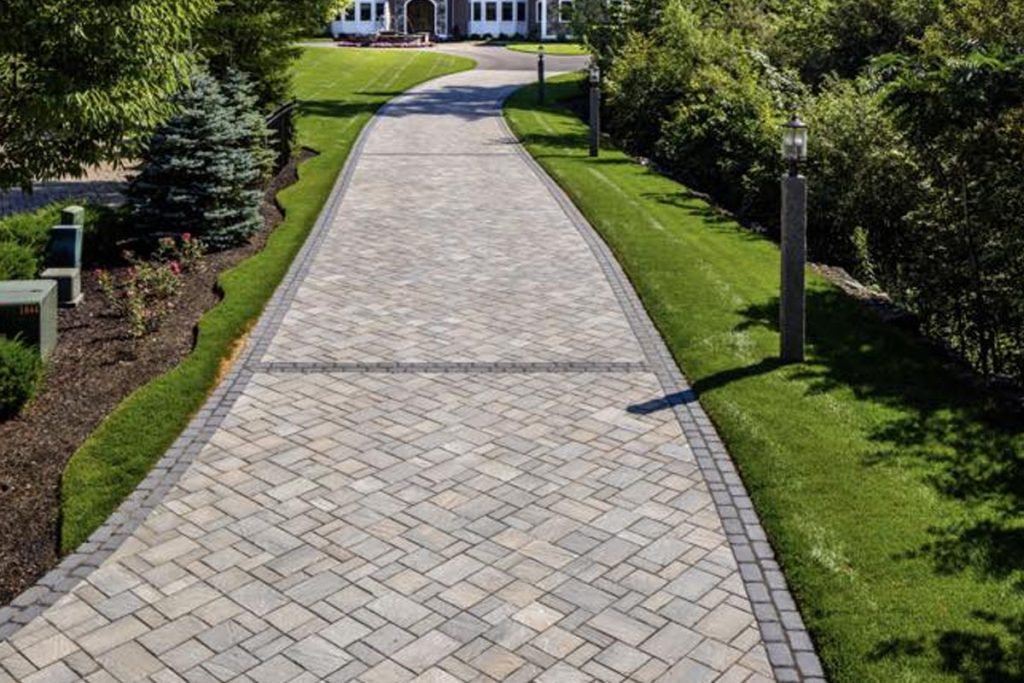 Elegant paver driveway leading to a large home in Fort Worth, TX, showing modern paver driveway ideas for improved curb appeal.