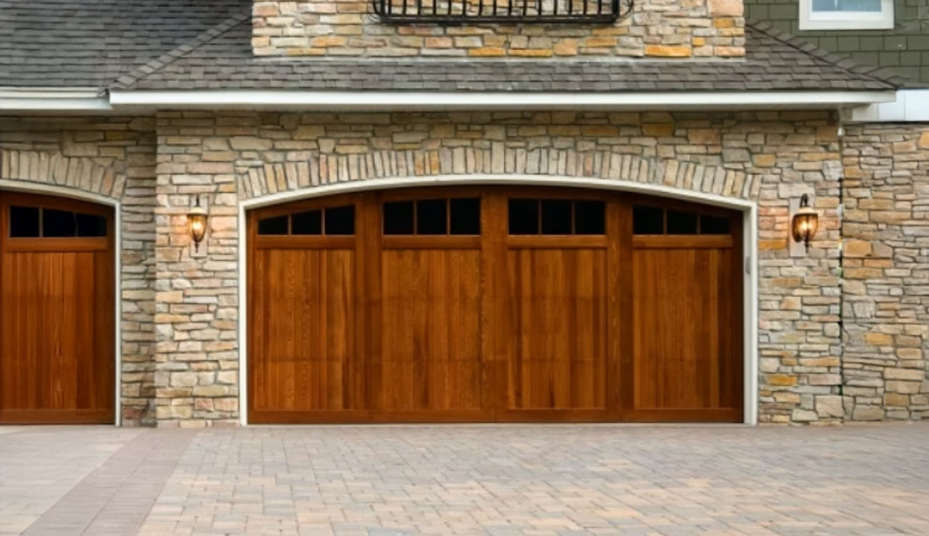 Stone paver driveway with wood garage doors in Fort Worth, TX, designed to boost curb appeal with natural texture and warm tones.