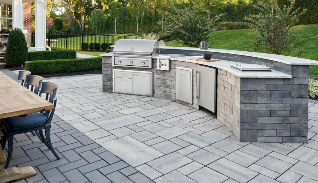 Holistic Patio Hardscaping Services in Fort Worth, TX - Holistic Patio Modern Outdoor Kitchen Ideas 1 Compact white brick island with stainless steel appliances set against a modern, geometric paved patio.