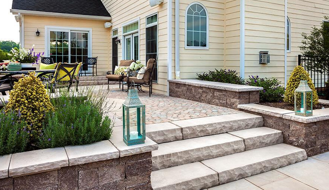 Holistic Patio Hardscaping Services in Fort Worth, TX - Holistic Patio Patio Decor Ideas Tiered paver patio showcases elegant steps, soft landscaping, lantern accents, and comfortable seating near the home.